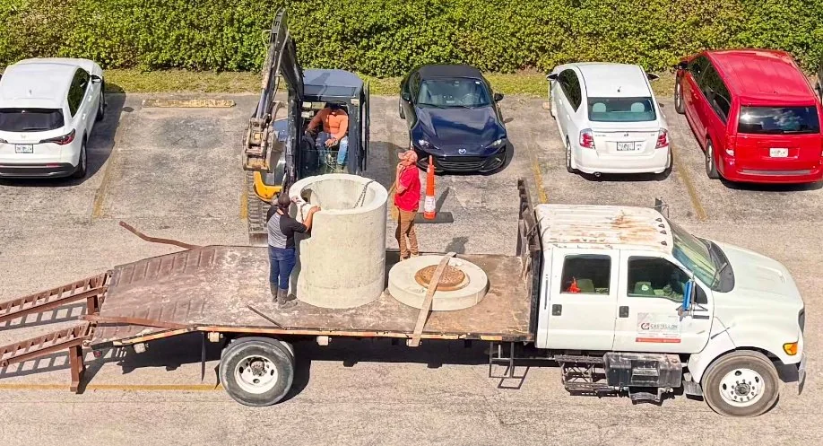 Castellon Services Corp truck, mini-excavator, and crew installing storm drainage in Doral FL